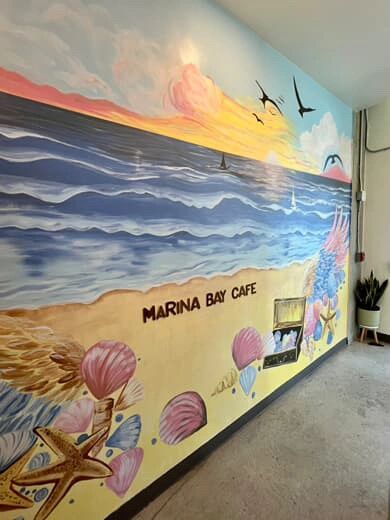 Photo of a beachy mural that says Marina Bay Cafe