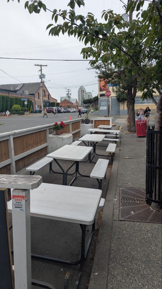Photo of white picnic tables in a parking space patio